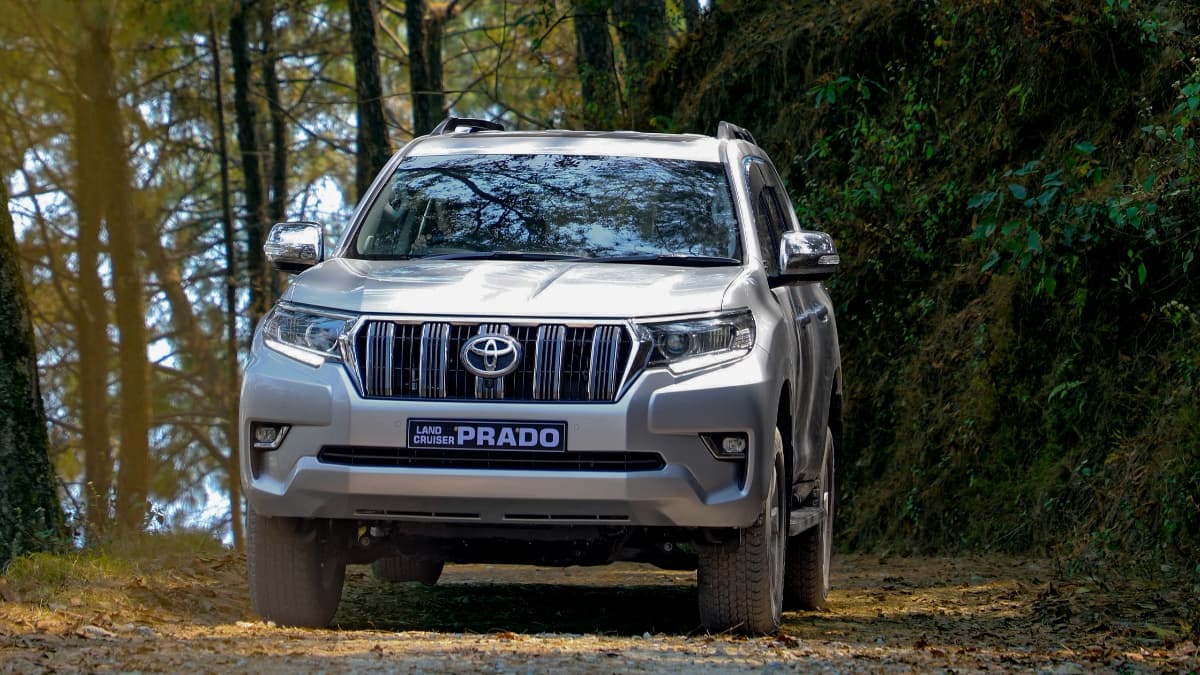 ed Toyota Fortuner SUV driving on a scenic mountain road in Nepal